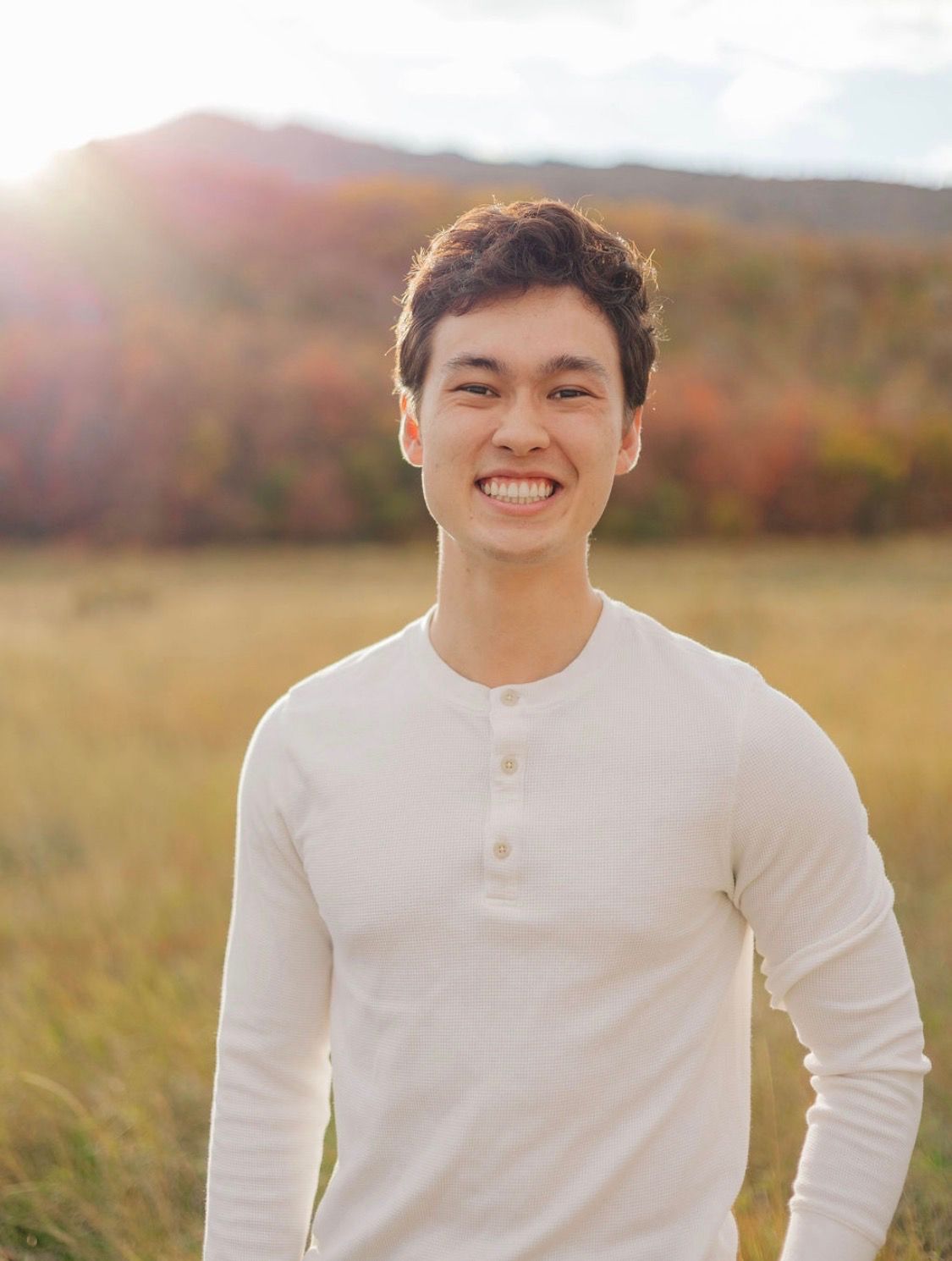 Eli Morgan, founder of Sakaya, smiling in a mountain meadow at golden hour